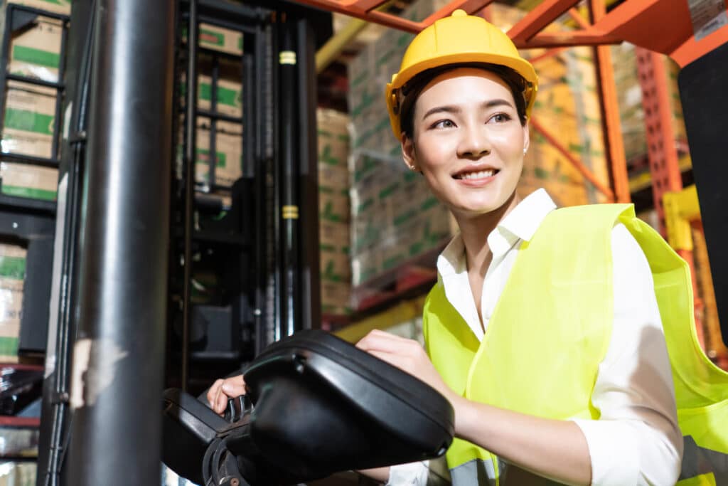 Portrait of warehouse woman worker smile while controlling