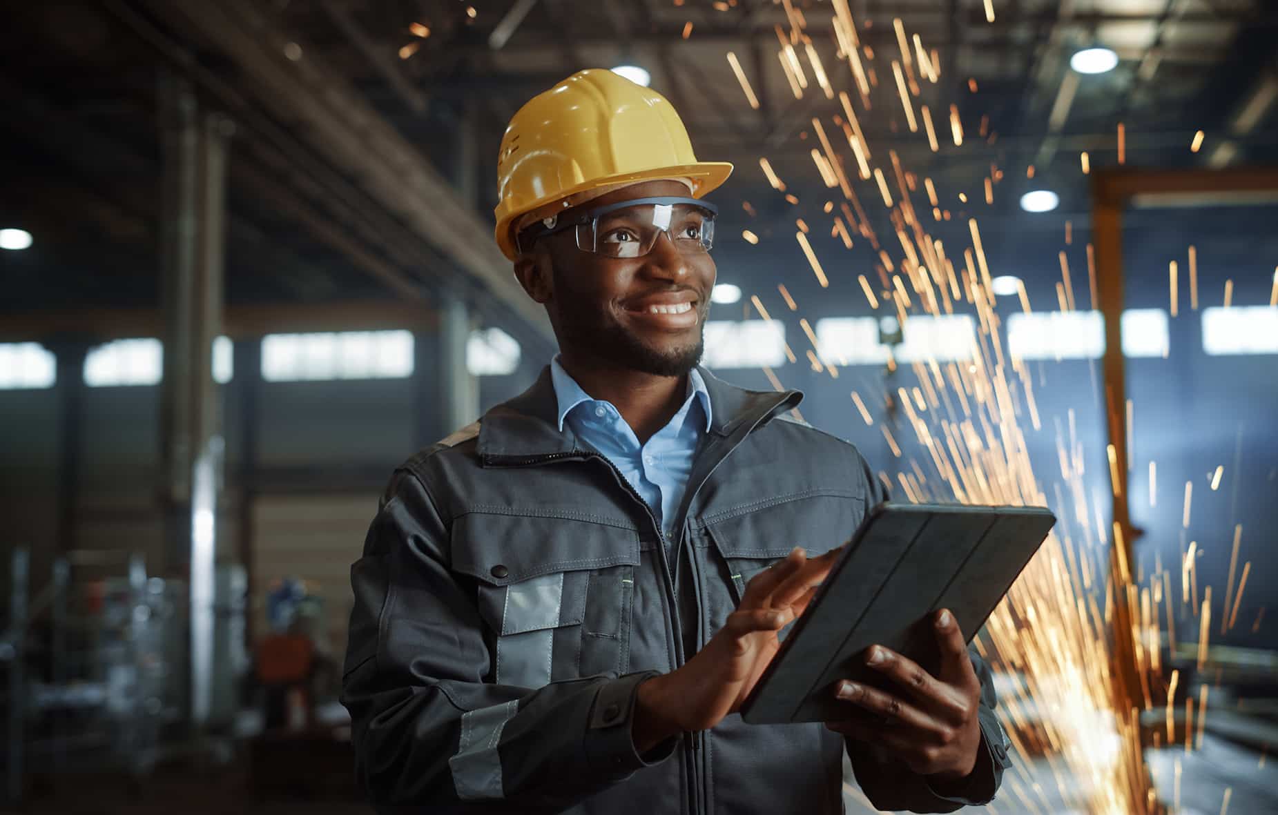 Professional Heavy Industry Engineer/Worker Wearing Safety Uniform and Hard Hat Uses Tablet Computer.